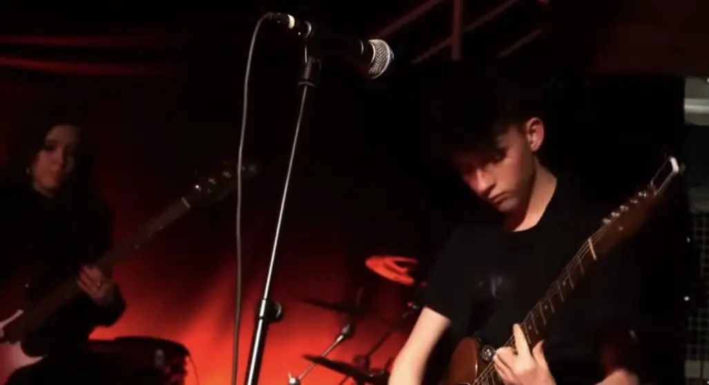 Guitarist på en mørk scene med rødt lys