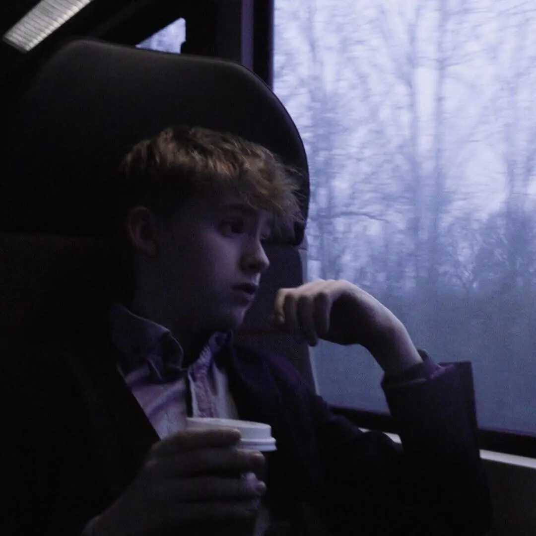 Bertram i et tog med en kop kaffe
